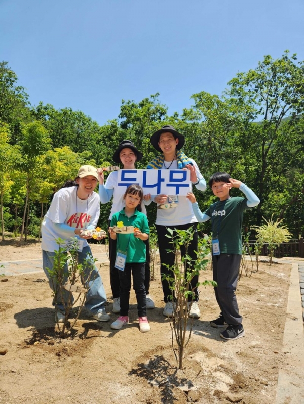 지난 17일 두나무 임직원 및 가족들이 국립춘천숲체원에서 진행된 나무심기 봉사활동에서 나무를 심은 뒤 기념 사진을 찍고 있다.(제공=두나무)